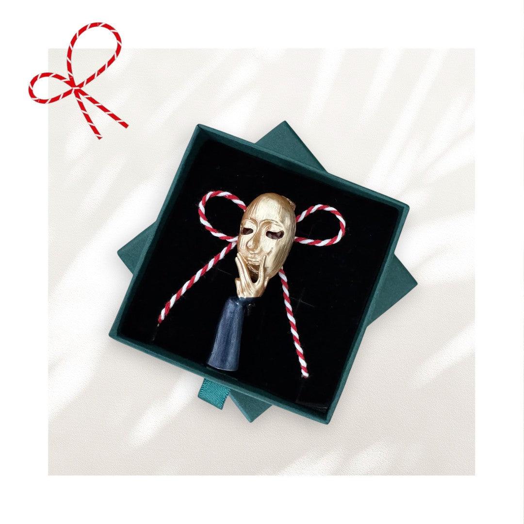 Brosa aurie, forma de masca de teatru, cu snur de martisor si cutiuta cadou, Alva - Pursehuit.ro